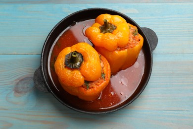 Photo of Tasty stuffed peppers on light blue wooden table, top view