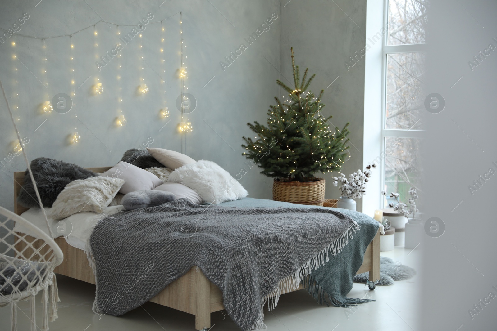 Photo of Elegant bedroom interior with little decorated Christmas tree