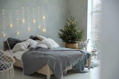 Elegant bedroom interior with little decorated Christmas tree