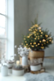 Blurred view of little Christmas tree in bedroom. Festive interior