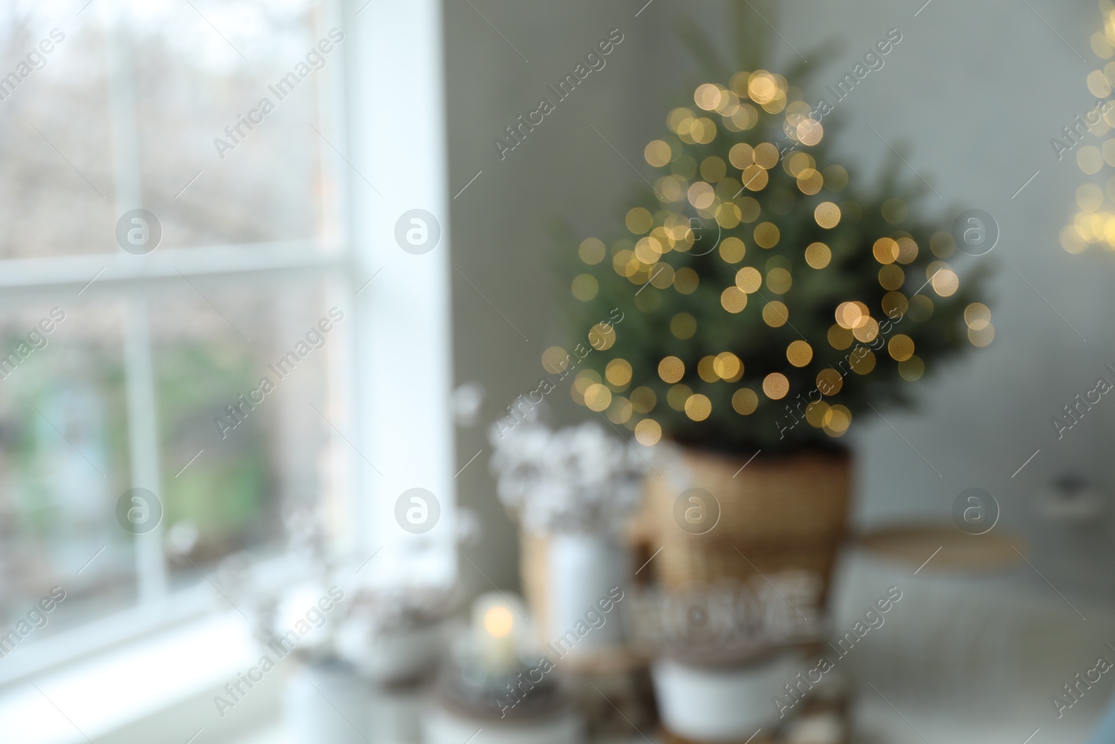 Photo of Blurred view of little Christmas tree in bedroom. Festive interior