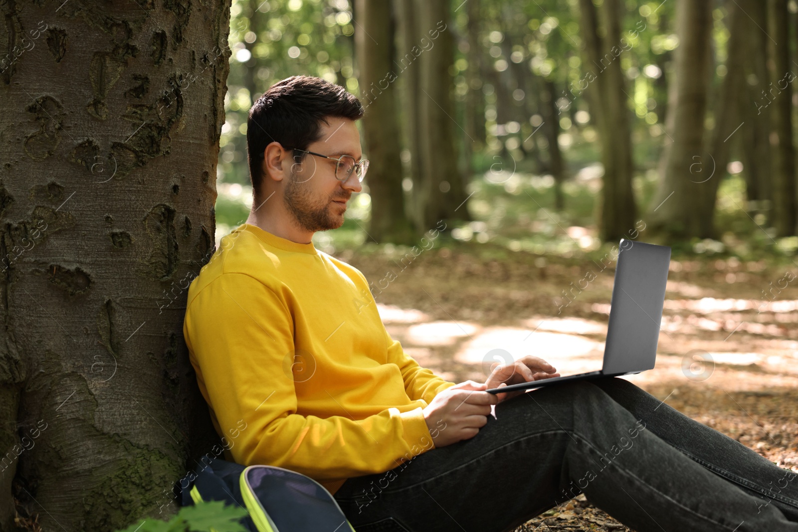 Photo of Traveler working with laptop outdoors. Remote job