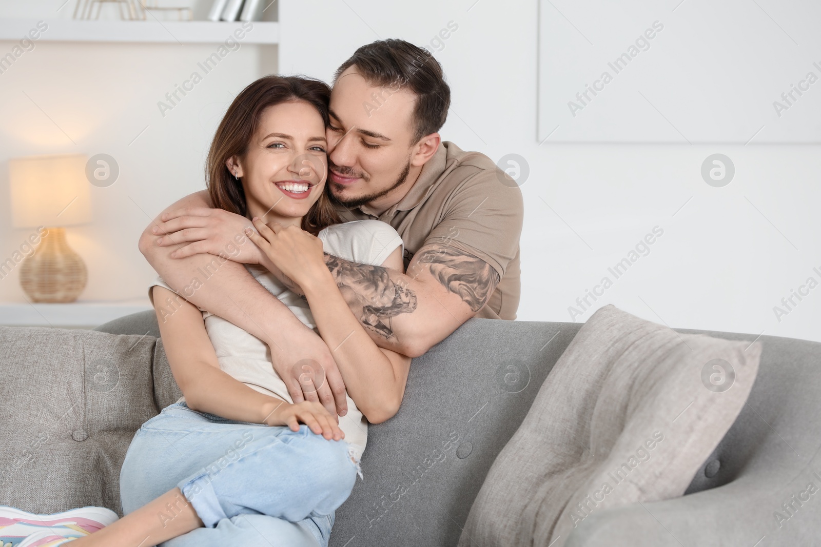 Photo of Man hugging his happy girlfriend at home