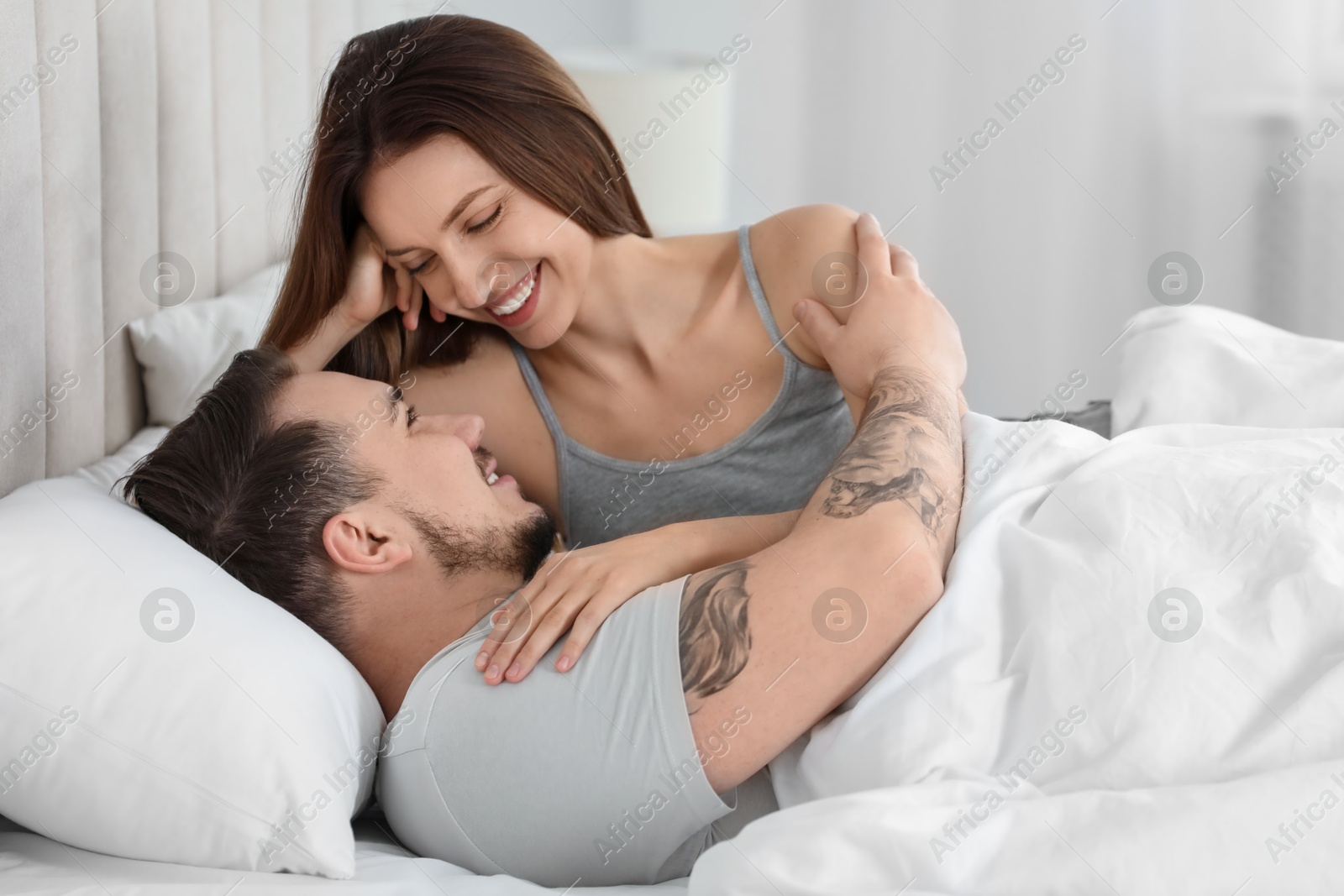 Photo of Happy couple enjoying each other in bed at home