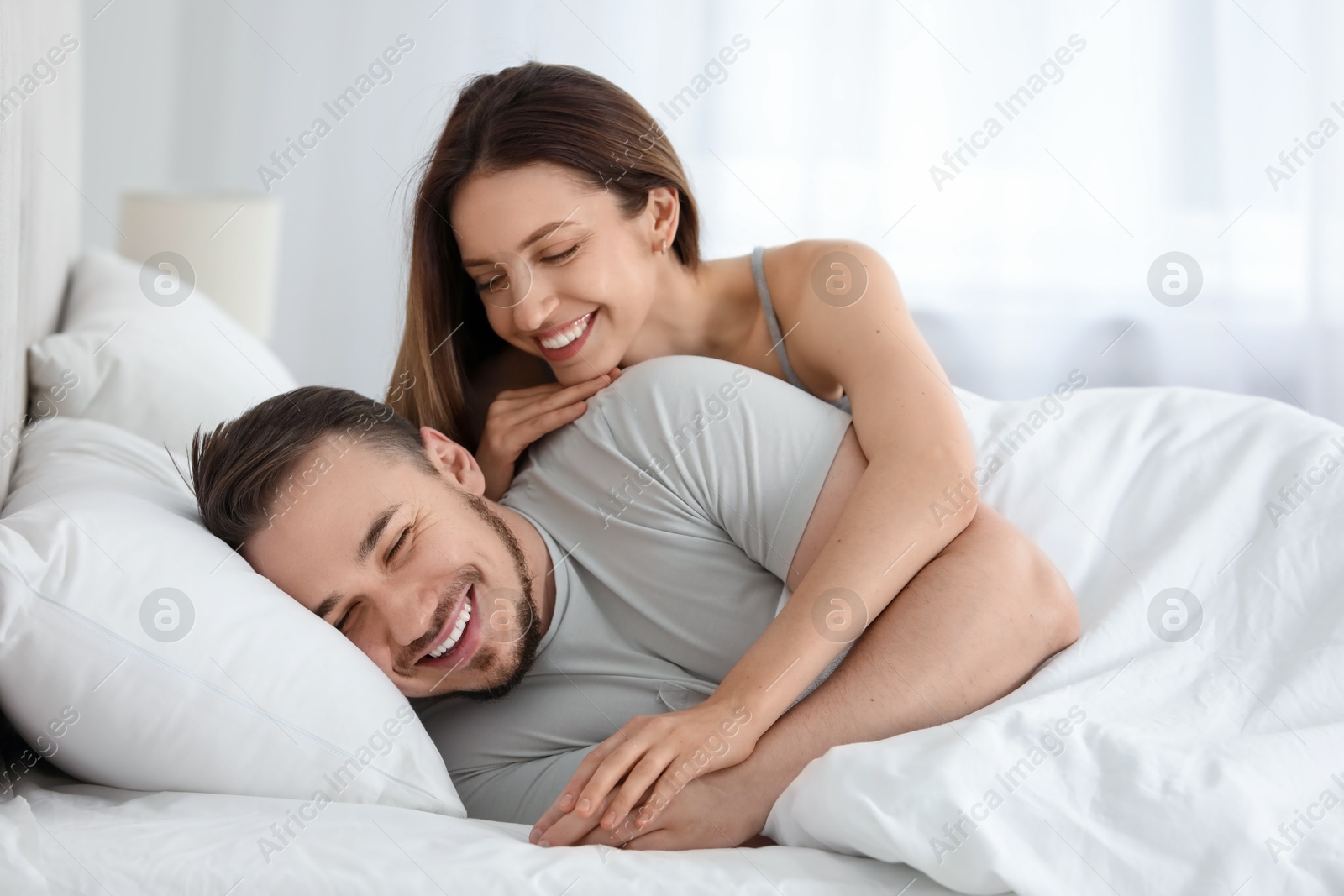 Photo of Happy couple enjoying each other in bed at home