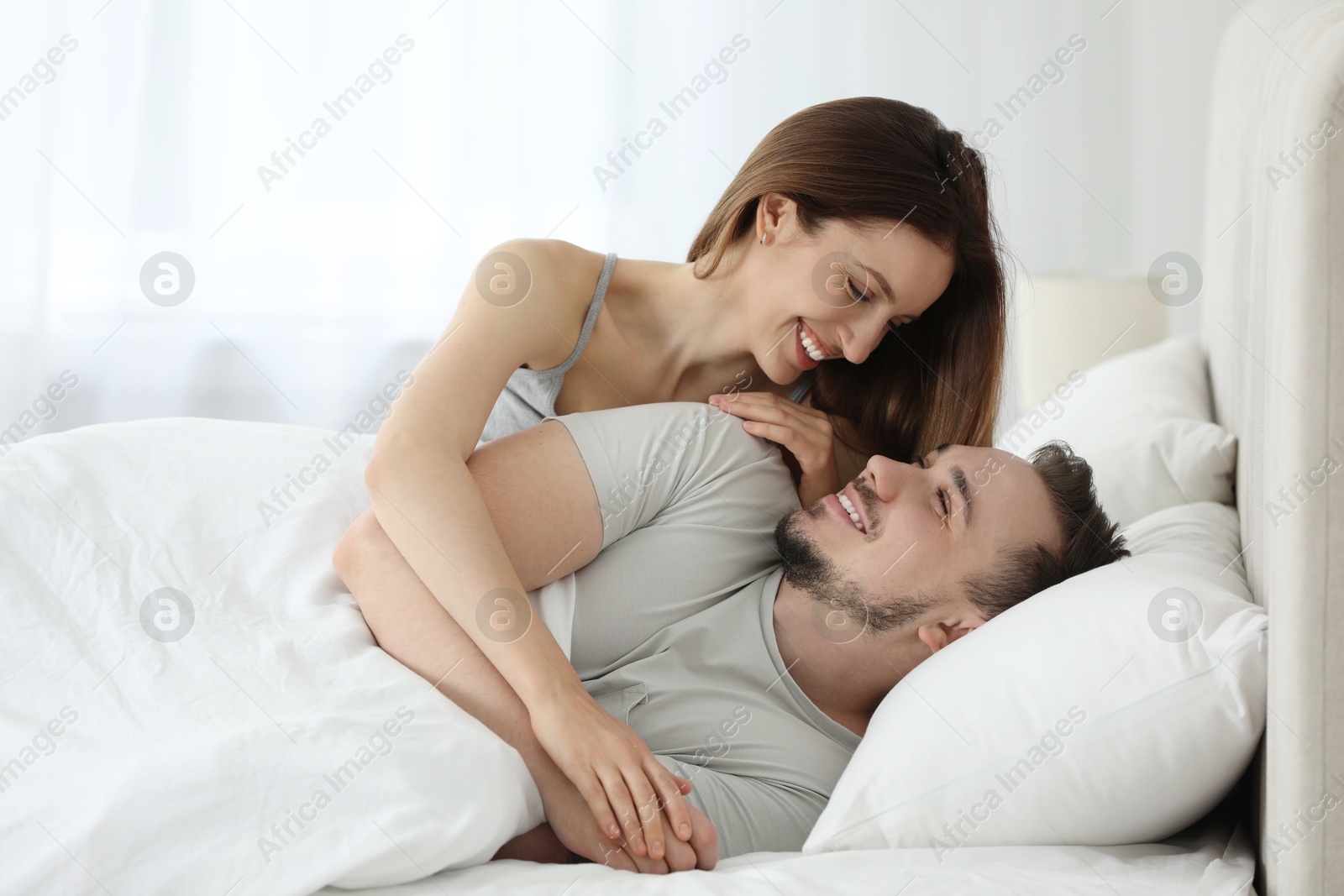 Photo of Happy couple enjoying each other in bed at home