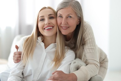 Family portrait of young woman and her mother at home