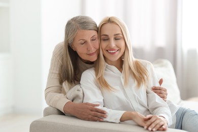 Photo of Family portrait of young woman and her mother at home