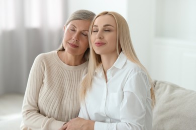 Family portrait of young woman and her mother at home