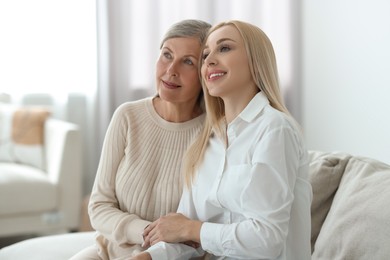 Family portrait of young woman and her mother at home