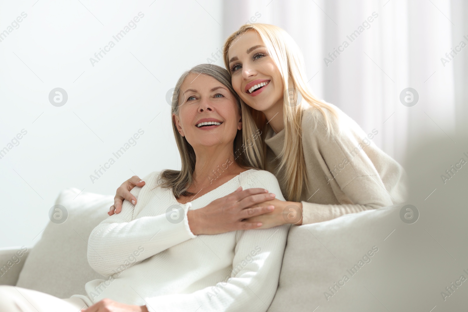 Photo of Family portrait of young woman and her mother at home