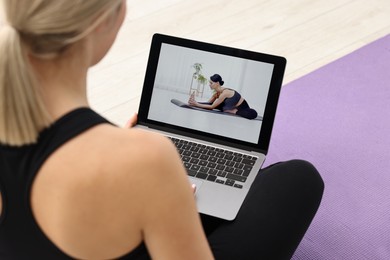 Photo of Online fitness trainer. Woman watching tutorial on laptop indoors, closeup