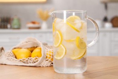 Photo of Freshly made lemonade in jug on wooden table indoors