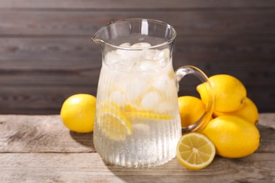 Photo of Freshly made lemonade in jug on wooden table