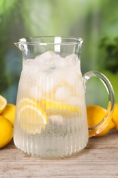 Freshly made lemonade in jug on wooden table outdoors