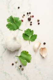 Fresh coriander leaves, garlic and peppercorns on light textured table, flat lay