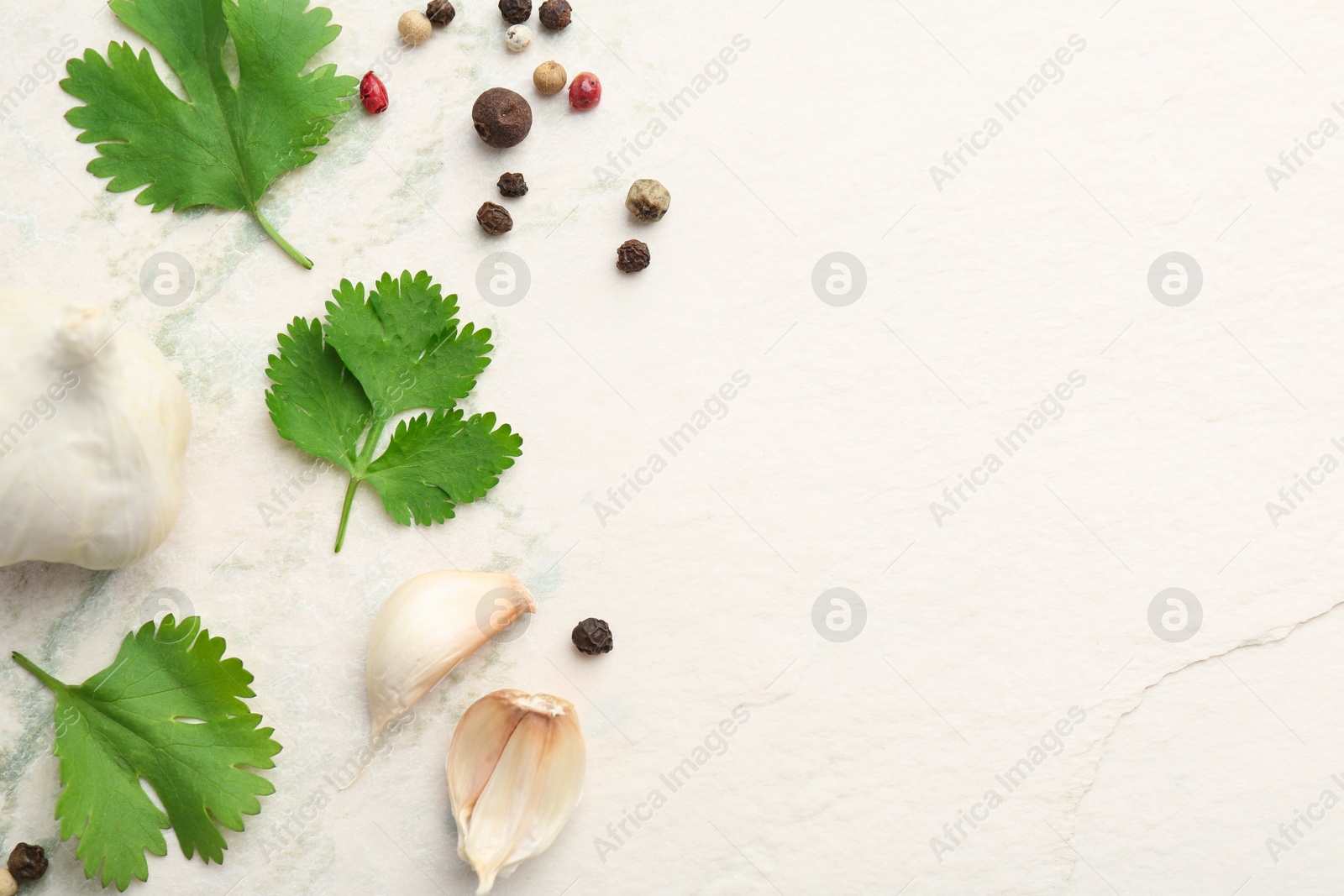 Photo of Fresh coriander leaves, garlic and peppercorns on light textured table, flat lay. Space for text