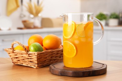 Freshly made lemonade in jug and citrus fruits on wooden table in kitchen