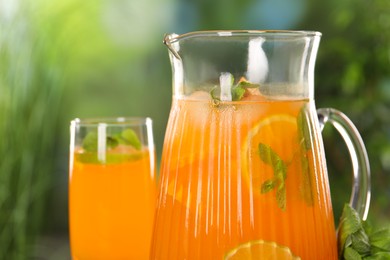 Freshly made lemonade in jug and glass outdoors