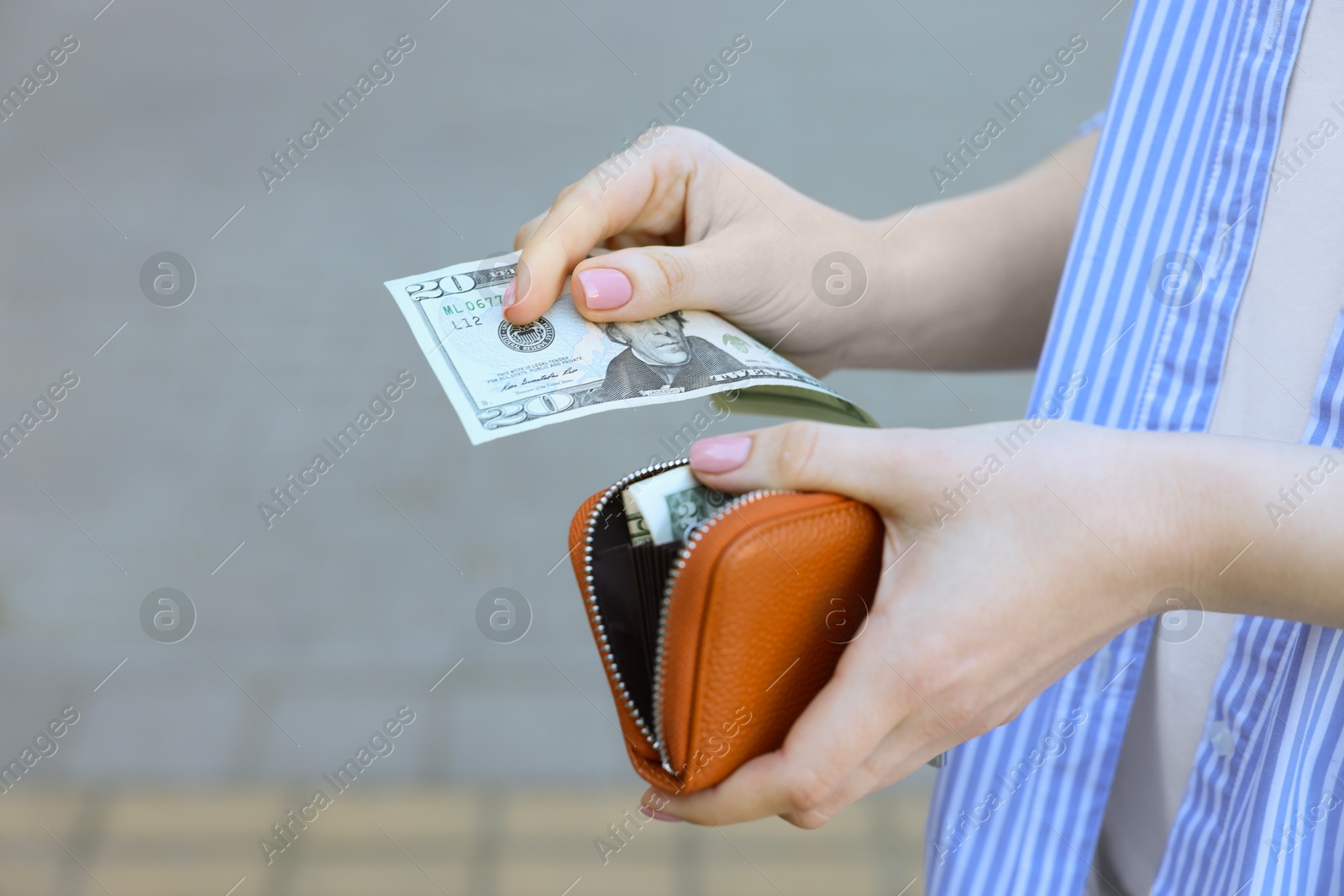 Photo of Woman holding purse with banknotes outdoors, closeup. Space for text