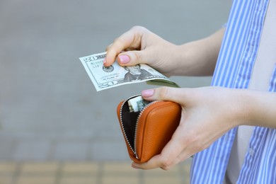 Photo of Woman holding purse with banknotes outdoors, closeup. Space for text