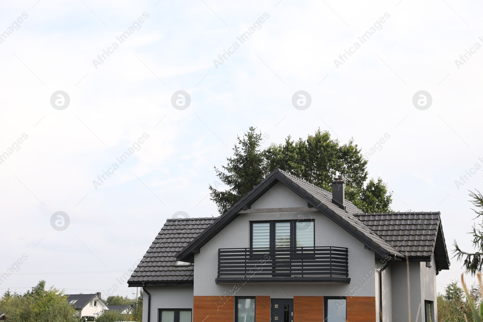 Photo of Beautiful beach house with balcony and trees outdoors