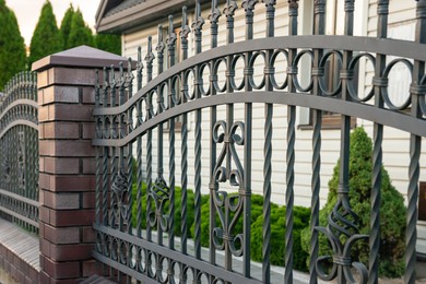 Beautiful brick fence with iron railing outdoors