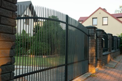 Photo of Beautiful brick fence with iron railing outdoors