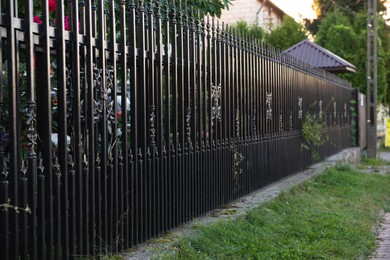 Beautiful black iron fence near pathway outdoors