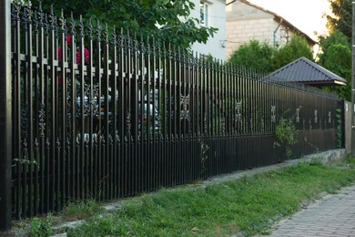 Photo of Beautiful black iron fence near pathway outdoors