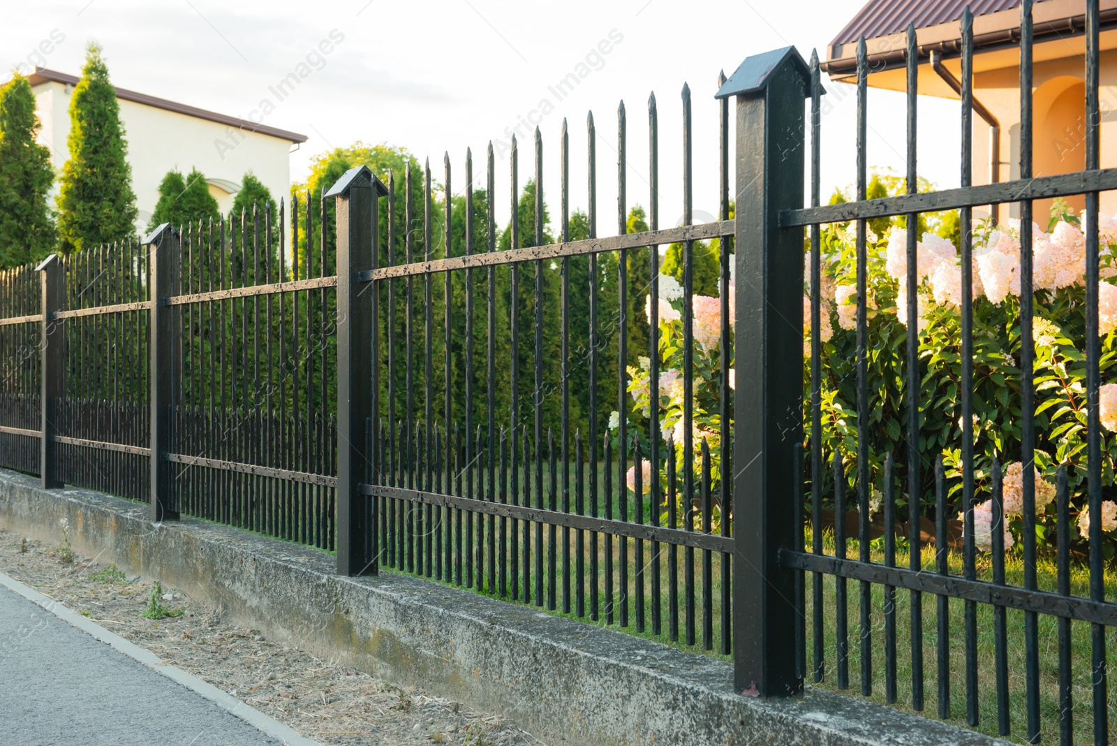 Photo of Beautiful black iron fence near pathway outdoors