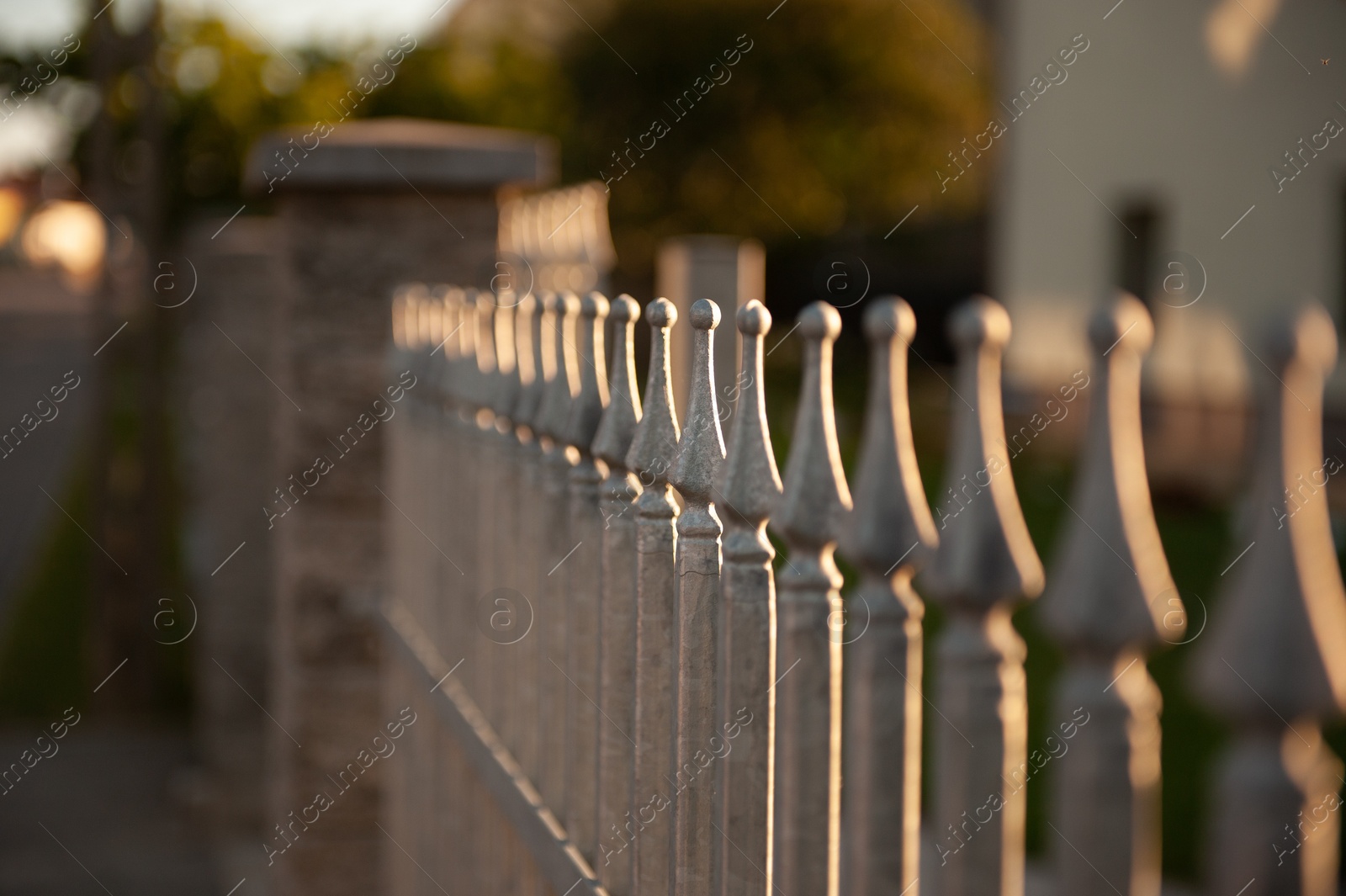 Photo of Beautiful iron fence on sunny day outdoors, closeup