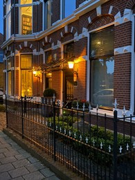 Flowerbed in front of brick house. Landscape design