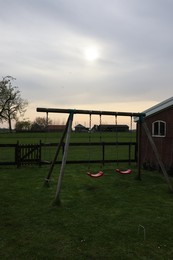 Photo of Spacious backyard with swing set in early morning
