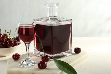 Photo of Delicious cherry liqueur and berries on white table