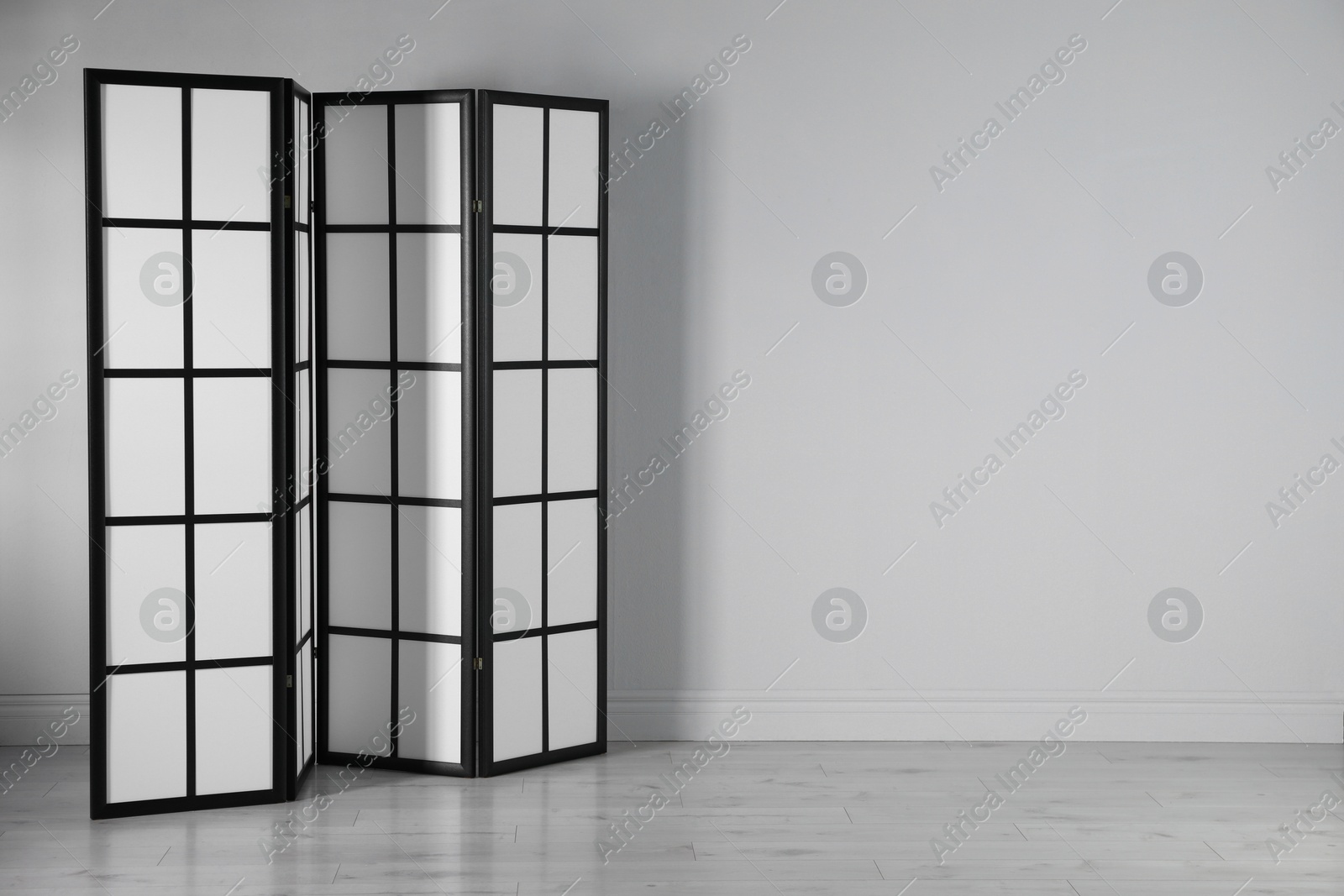 Photo of One folding screen near white wall indoors, space for text