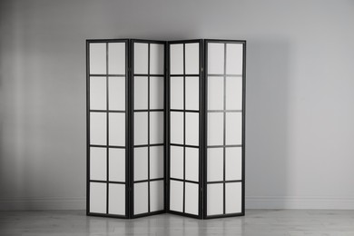 Photo of One folding screen near white wall indoors