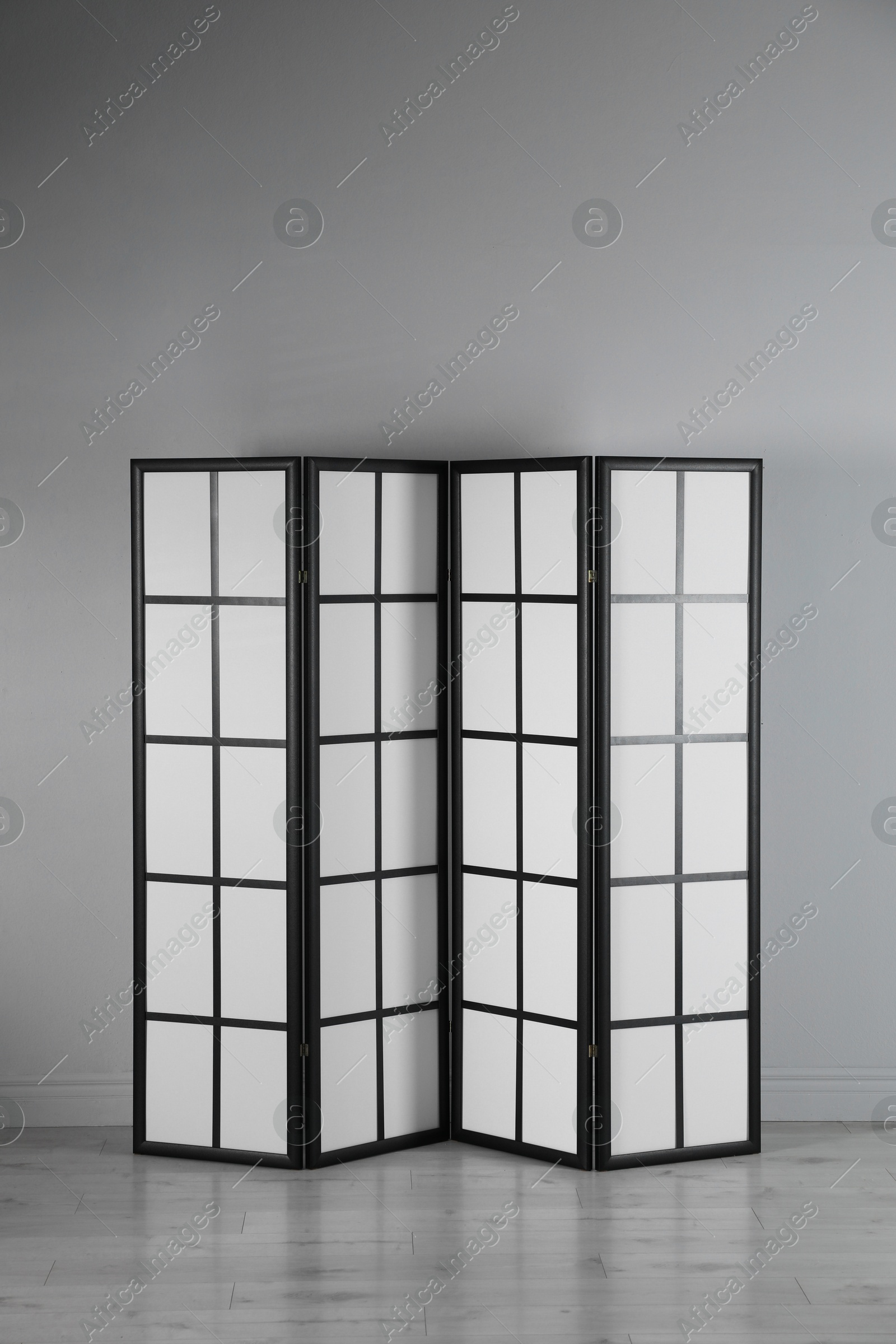 Photo of One folding screen near white wall indoors