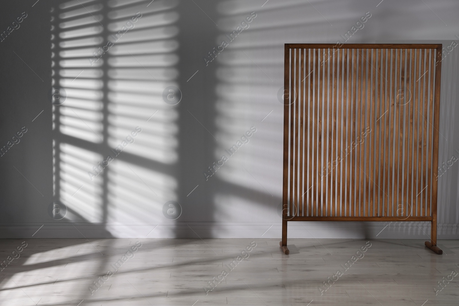 Photo of Wooden folding screen near light wall indoors, space for text