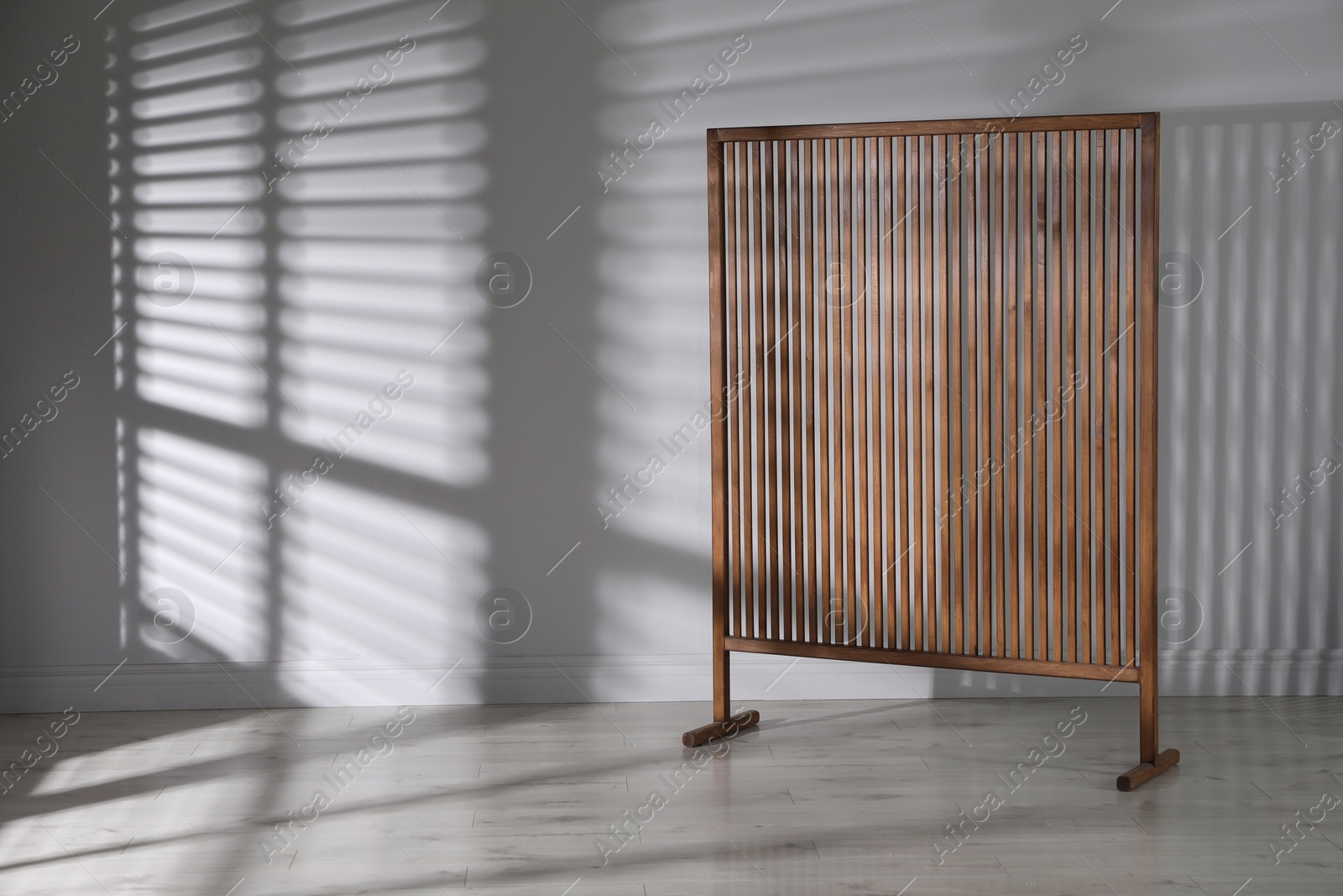 Photo of Wooden folding screen near light wall indoors, space for text