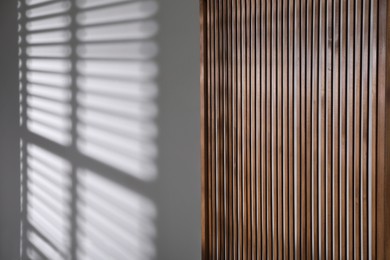 Photo of Wooden folding screen near light wall indoors, space for text