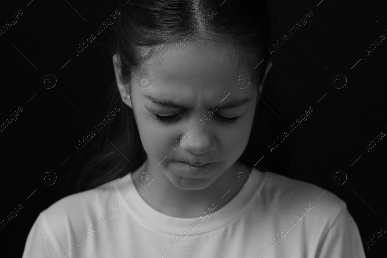 Photo of Portrait of sad girl in darkness, closeup. Black and white effect