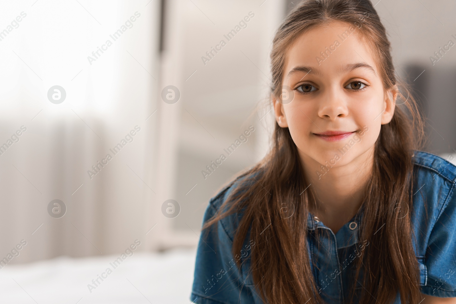 Photo of Portrait of cute little girl indoors, space for text