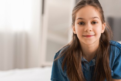 Photo of Portrait of cute little girl indoors, space for text