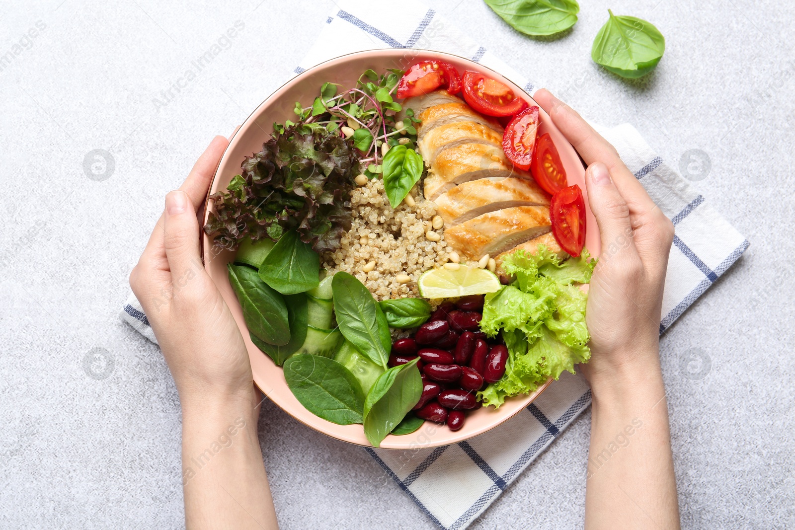 Photo of Healthy meal. Woman with bowl of tasty products at white table, top view