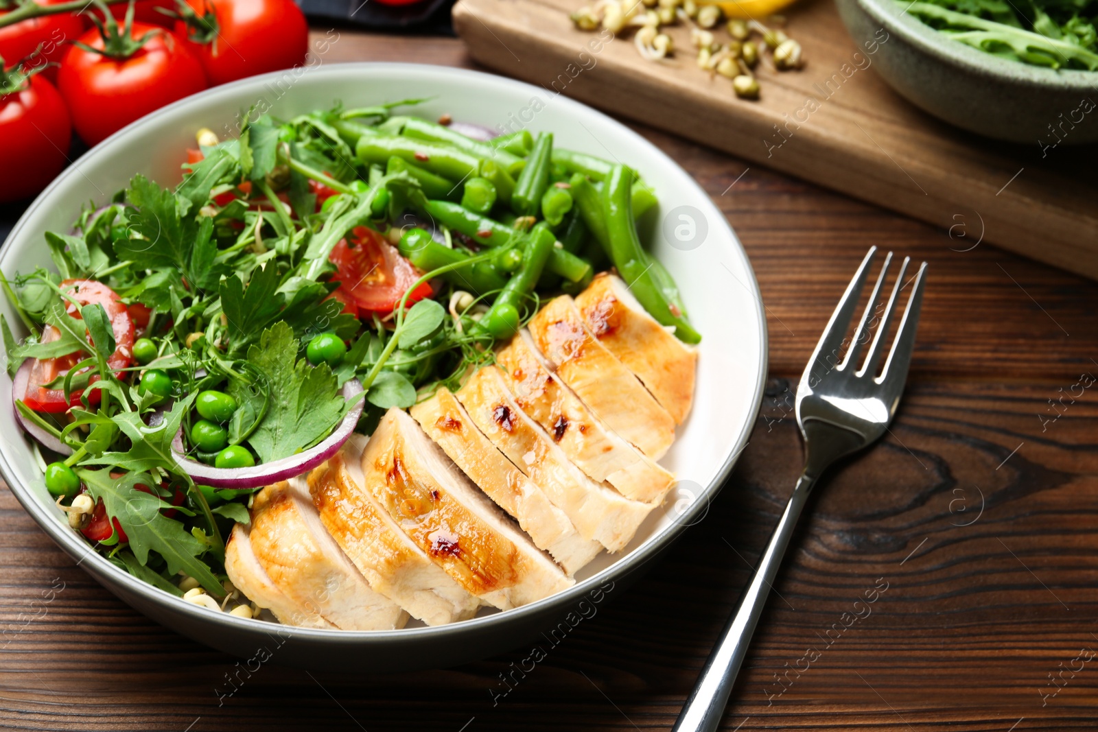 Photo of Healthy meal. Tasty salad and chicken breast in bowl on wooden table, closeup