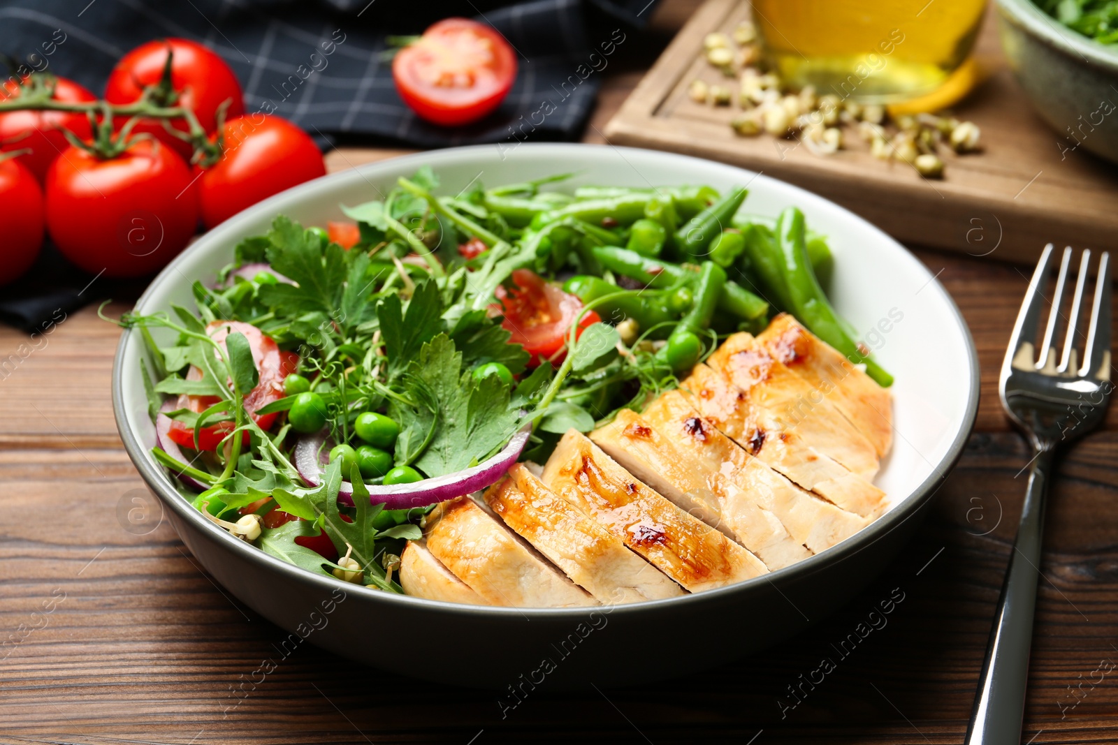 Photo of Healthy meal. Tasty salad and chicken breast in bowl on wooden table, closeup