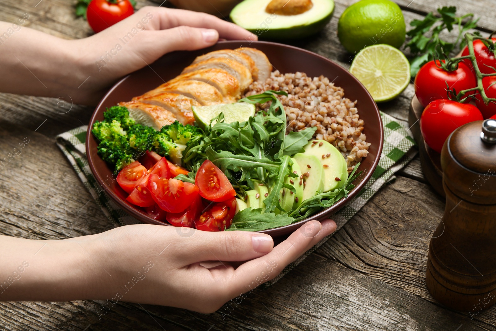 Photo of Healthy meal. Woman with tasty products in bowl at wooden table, closeup