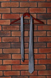 Photo of Hanger with striped necktie on red brick wall