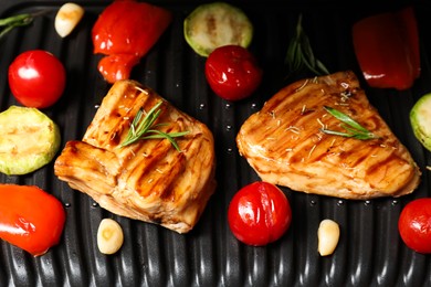 Photo of Tasty meat, spices and vegetables on electric grill, closeup